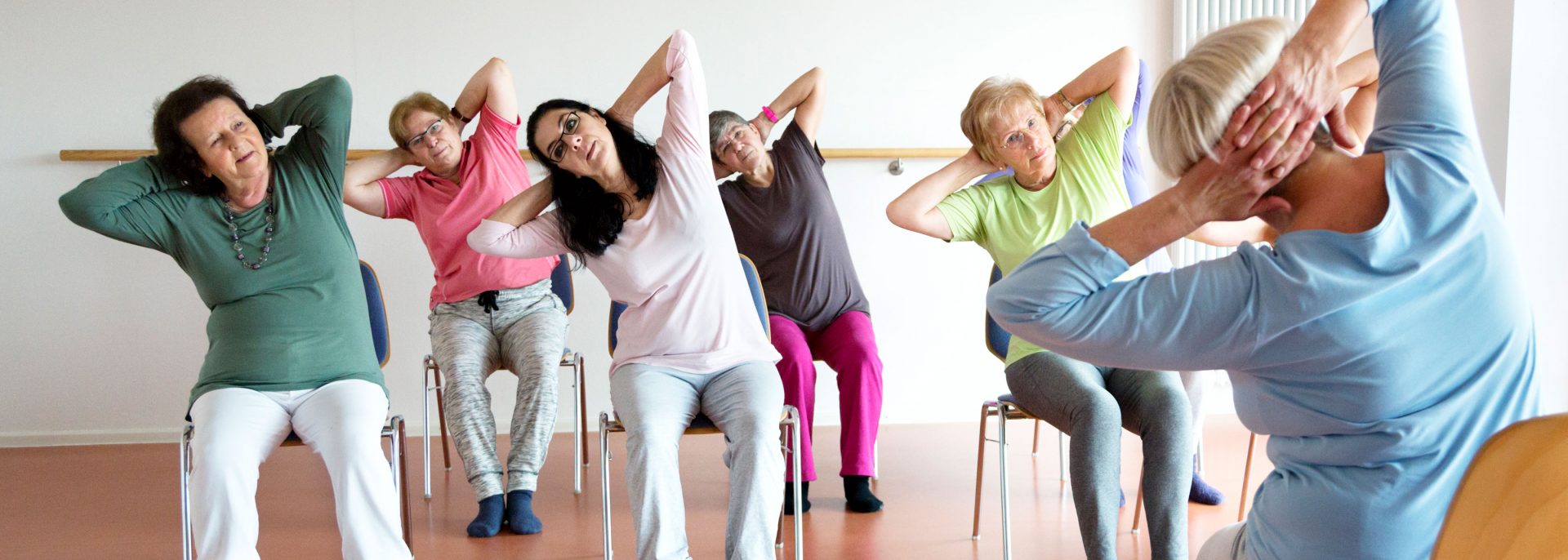 Allied Health women stretching whilst seated in active class