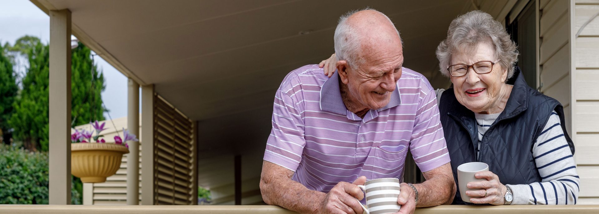 Aged care couple sipping coffee on patio