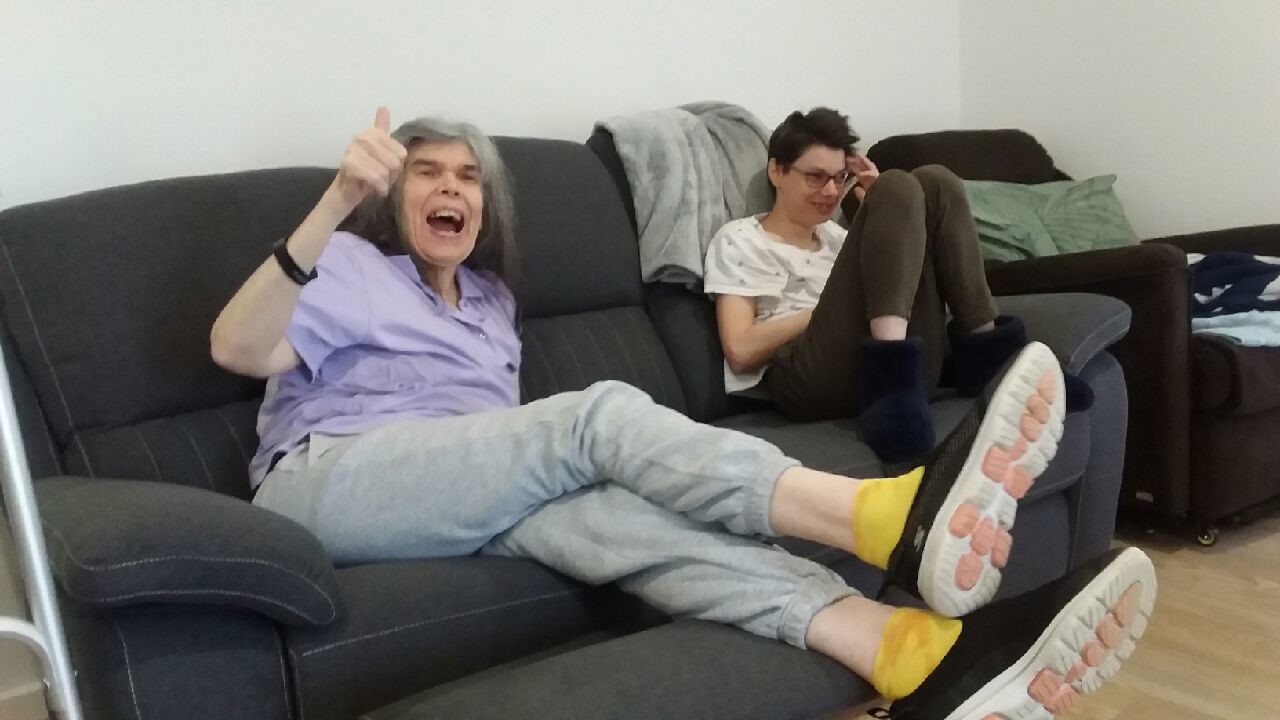 Two women smiling sitting on couch