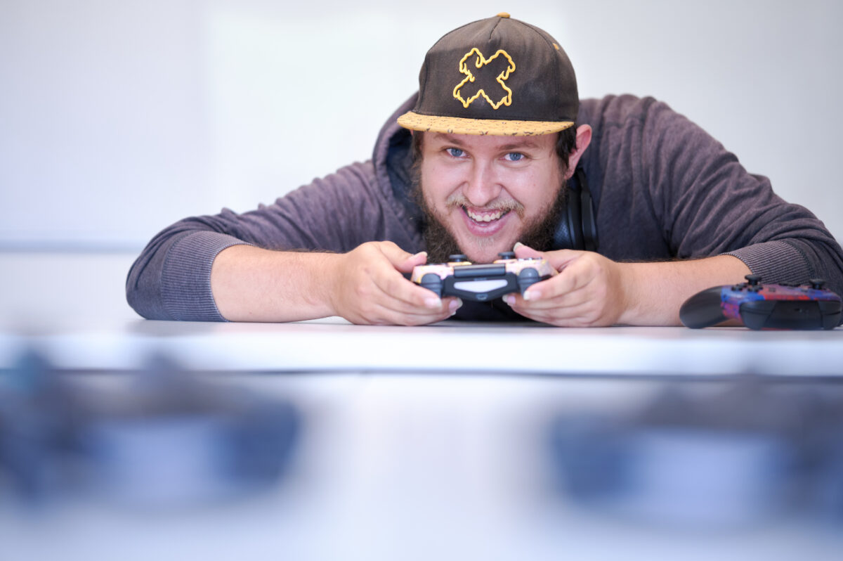 Man holding gaming controller laughing