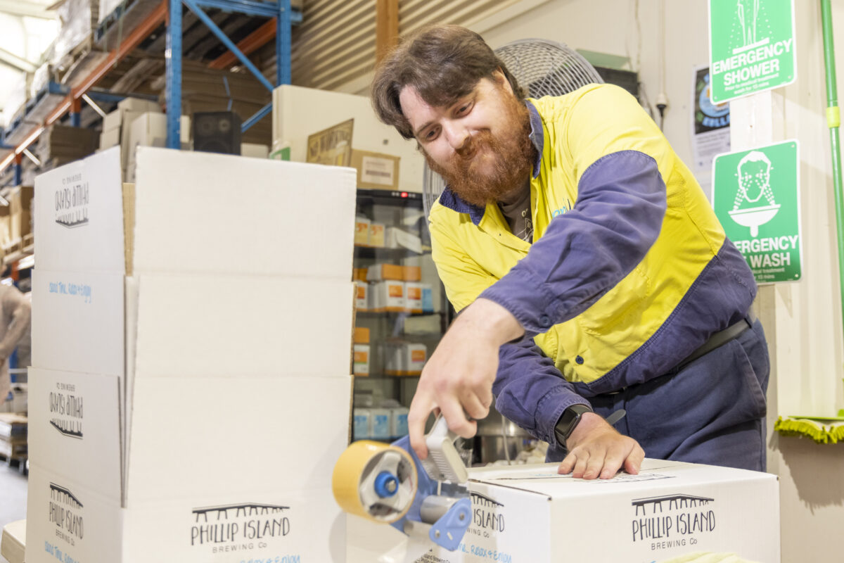 Male supported employee boxing up Prickly Moses Brewery products in a warehouse
