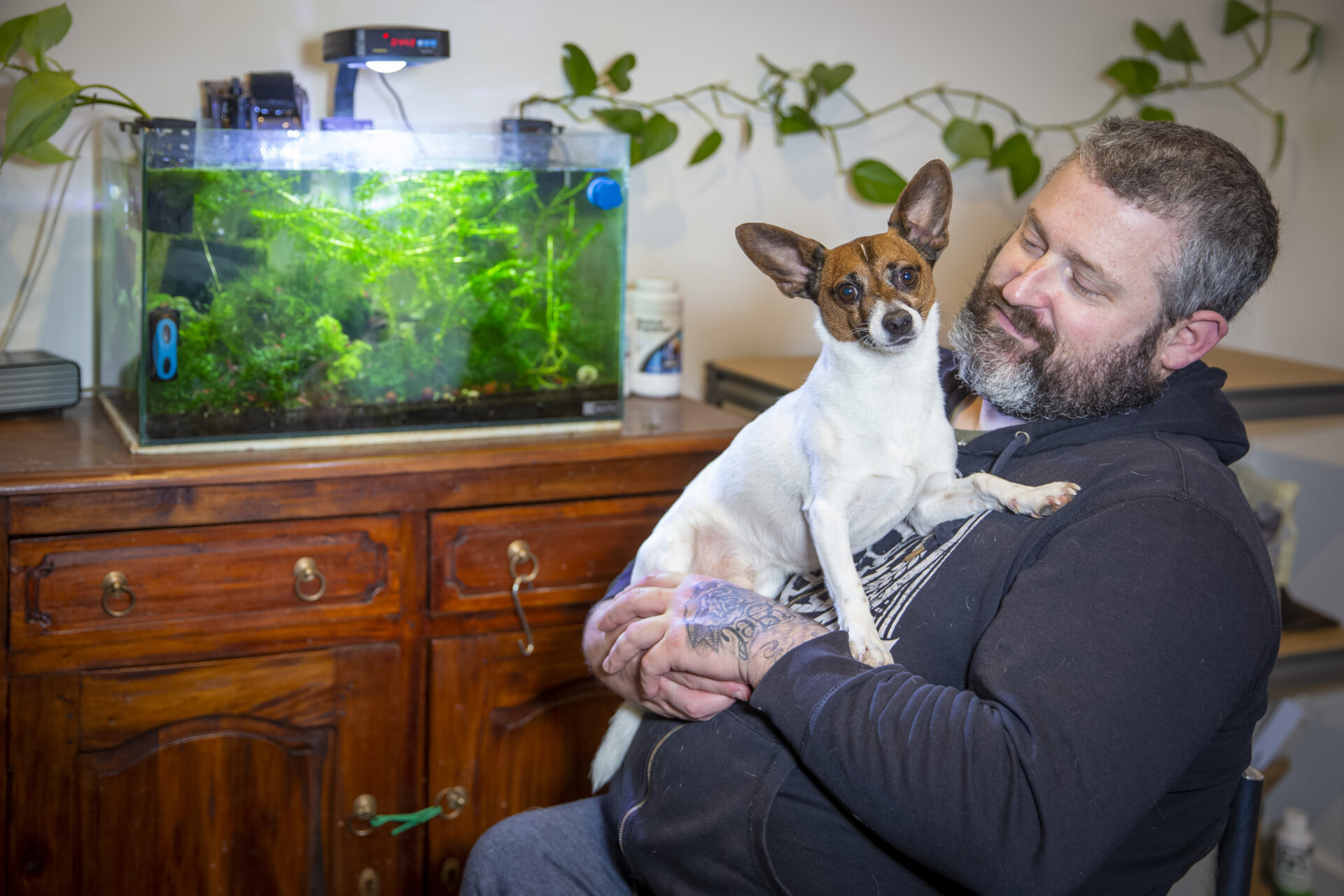 Brad holds his dog Tex inside his Highton Green SDA apartment