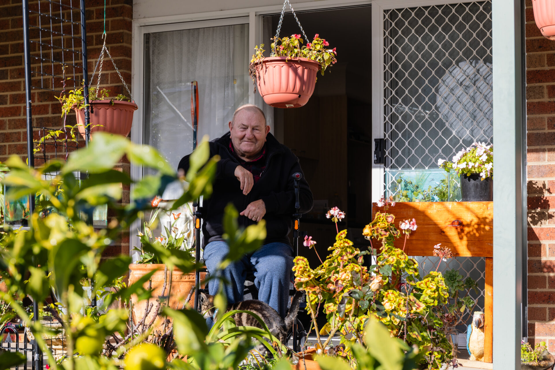 Ken is smiling as he sits on the veranda of his Kangaroo Flat unit.