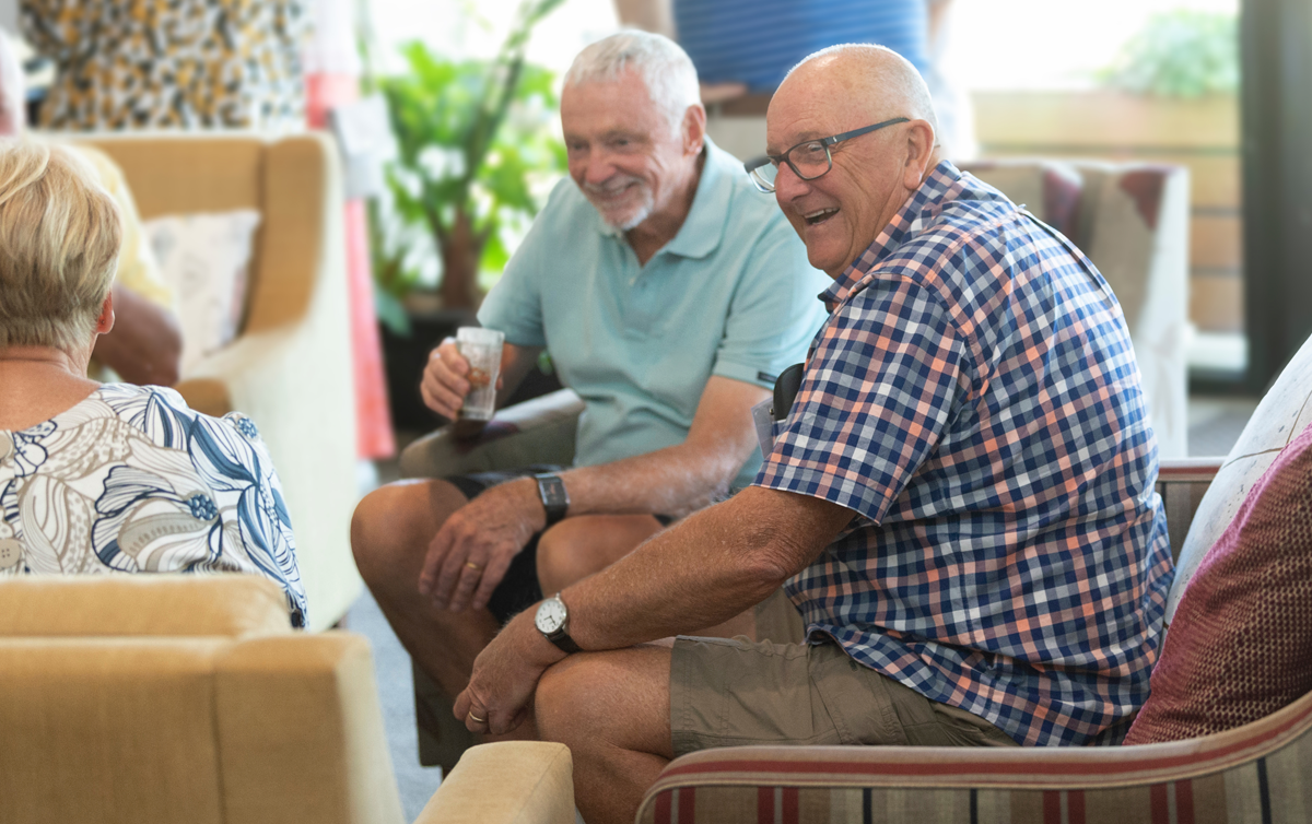 Two men and a woman are sitting down in a common area at the Barwarre Gardens Retirement Village.